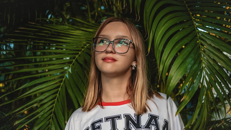 Portret dziewczyny w okularach przed obróbką — odblaski na szkłach